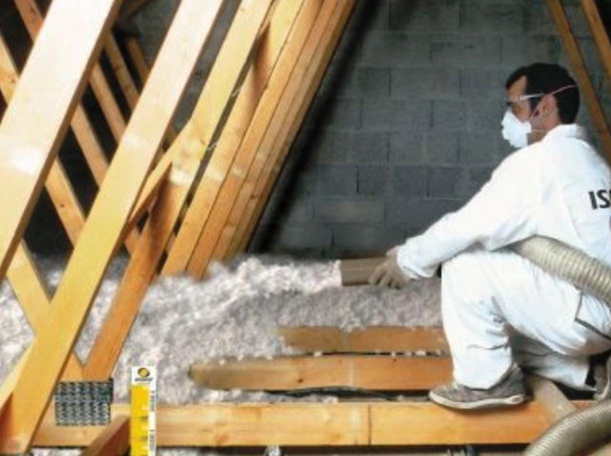 Artisan soufflant de l'isolant dans les combles